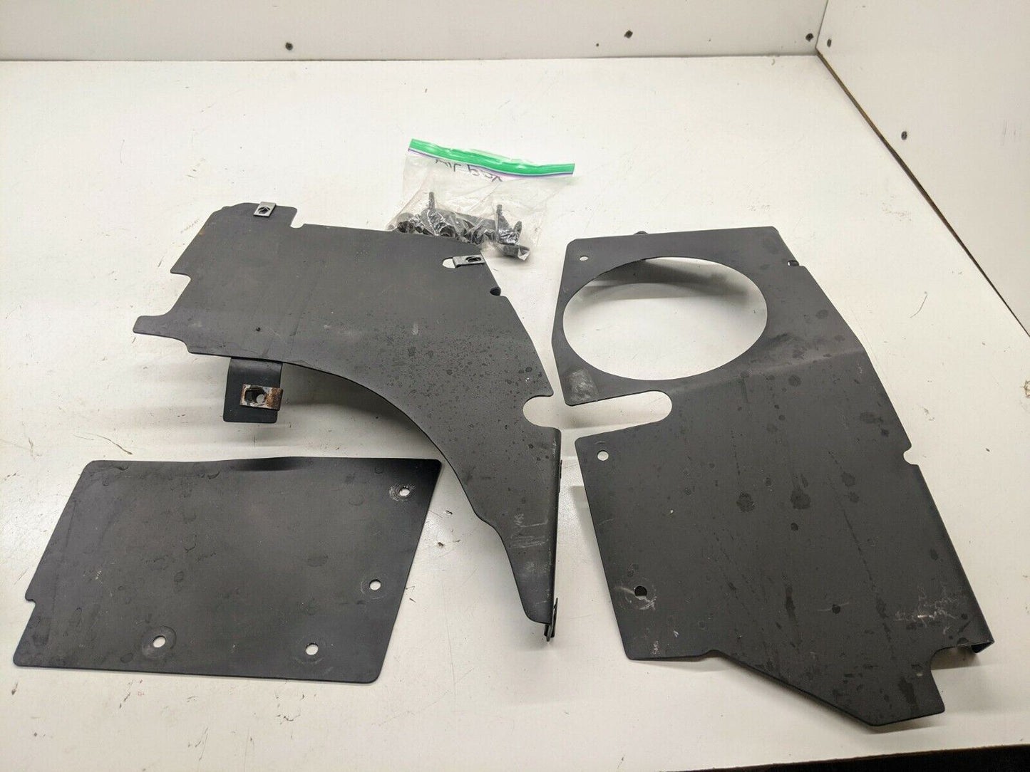Three custom flat black metal plates by The Ugly Truckling, plus screws, are arranged on a white surface—a complete kit for upgrading your 1995–2005 Chevy S10 or Blazer LS Swap Cold Air Box with a factory look.