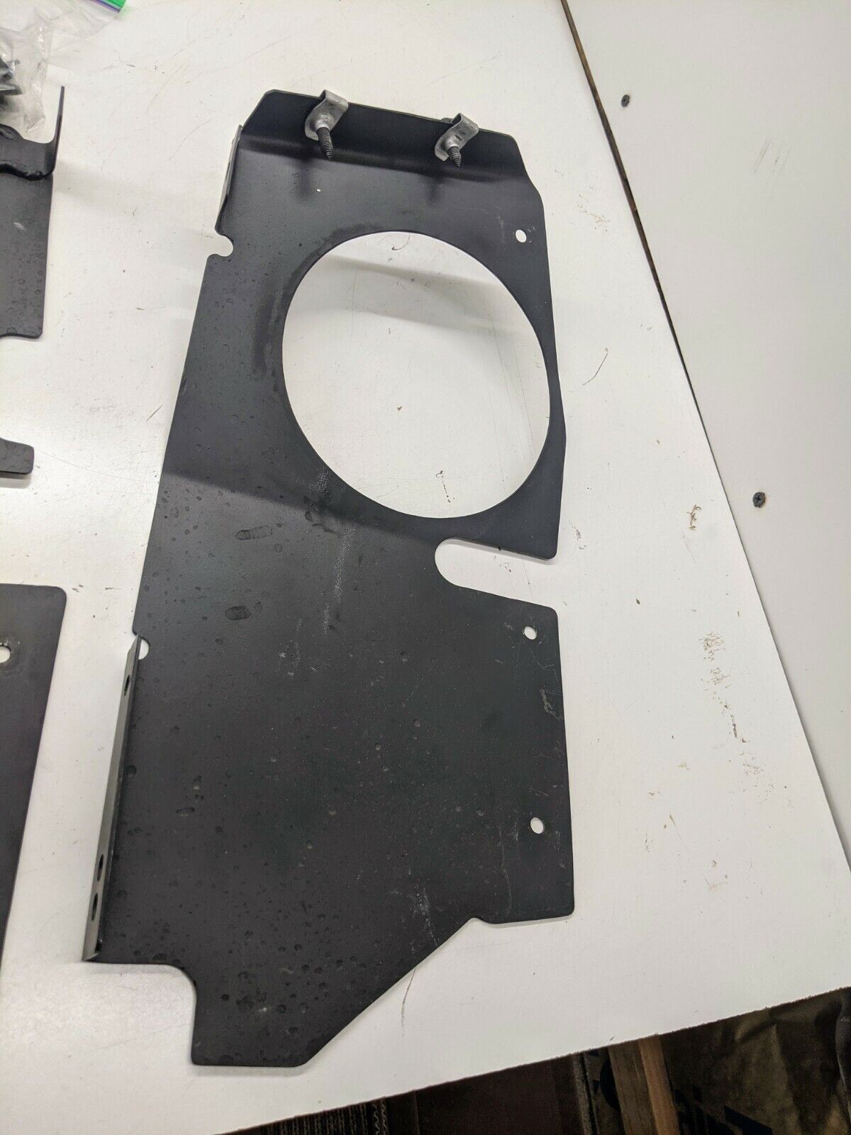 The Ugly Truckling 1995-2005 Chevy S10 Blazer LS Swap Cold Air Box custom fabricated black metal bracket with circular cutout and clips, perfect for mounting your air cleaner box, shown on a white surface.