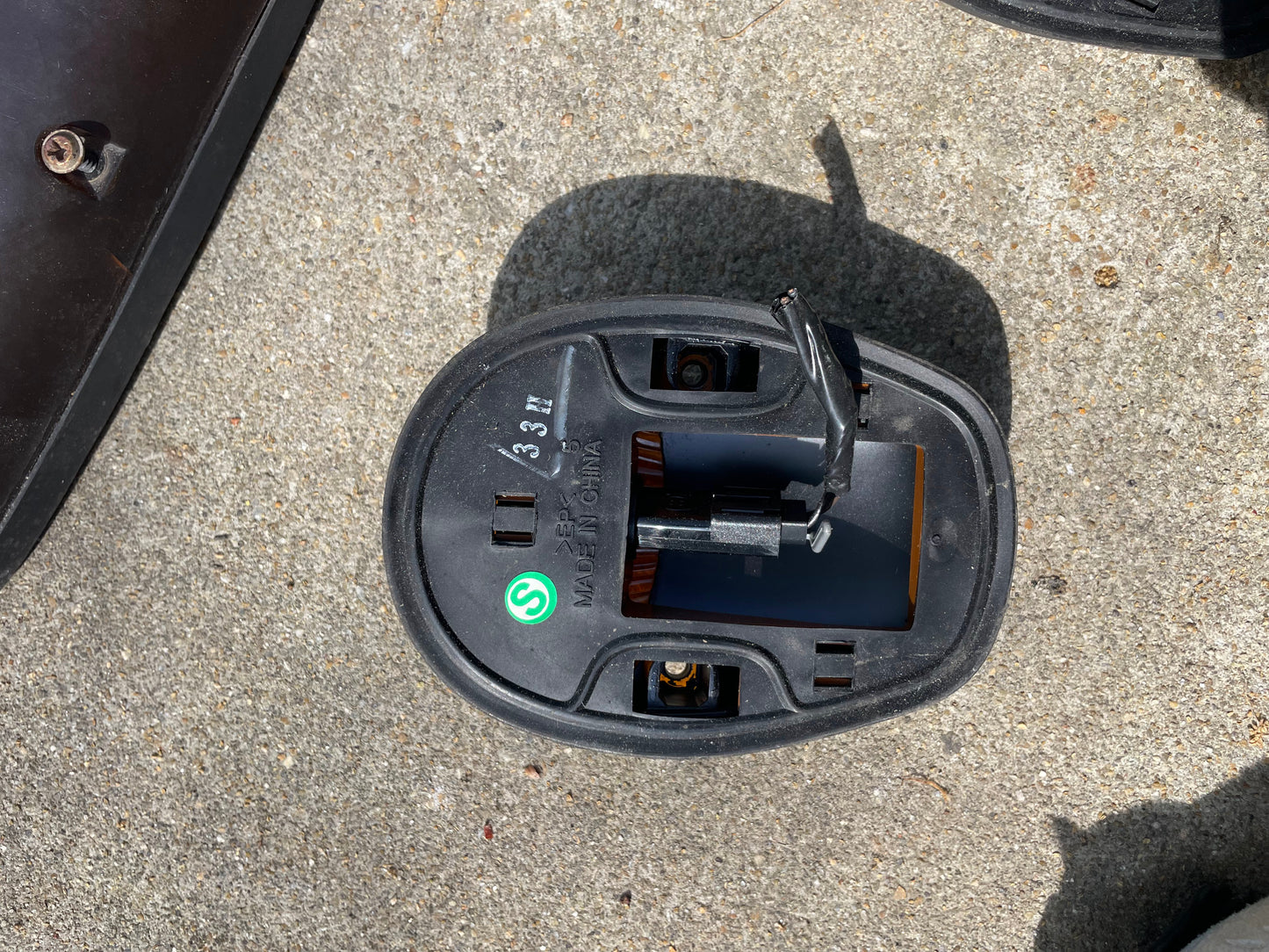 A close-up of a General Motors OEM roof light lamp cab lens set for 2000–2007 Chevrolet Silverado and Suburban, featuring left, right, and center lenses on a rough gray concrete surface in sunlight.