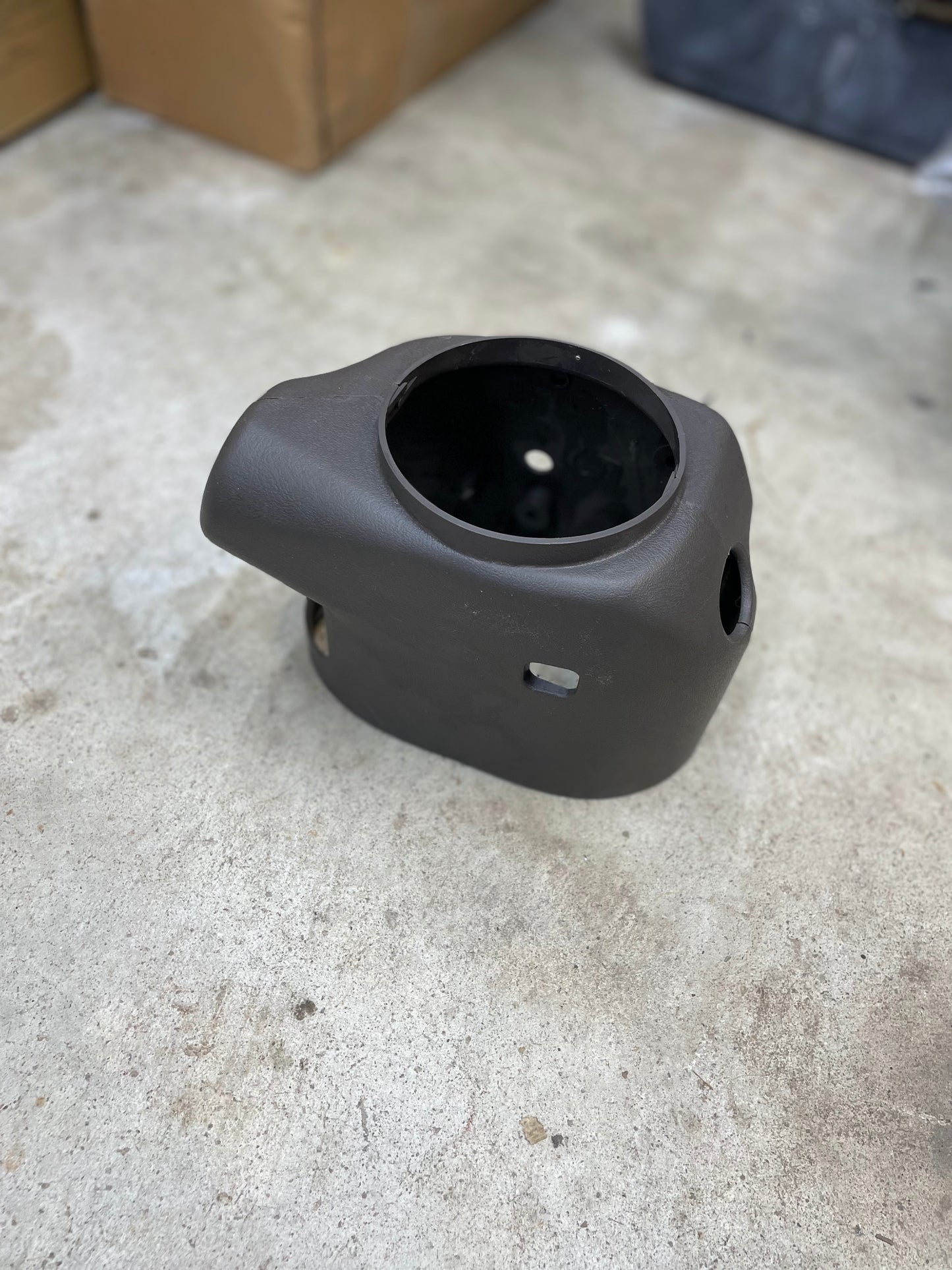 A black KIT Leather w/Wood Steering Wheel with radio controls from Escalade by General Motors, fitting 1995–2005 GM trucks, is shown on a light concrete floor with boxes behind—ideal for your restoration or upgrade.