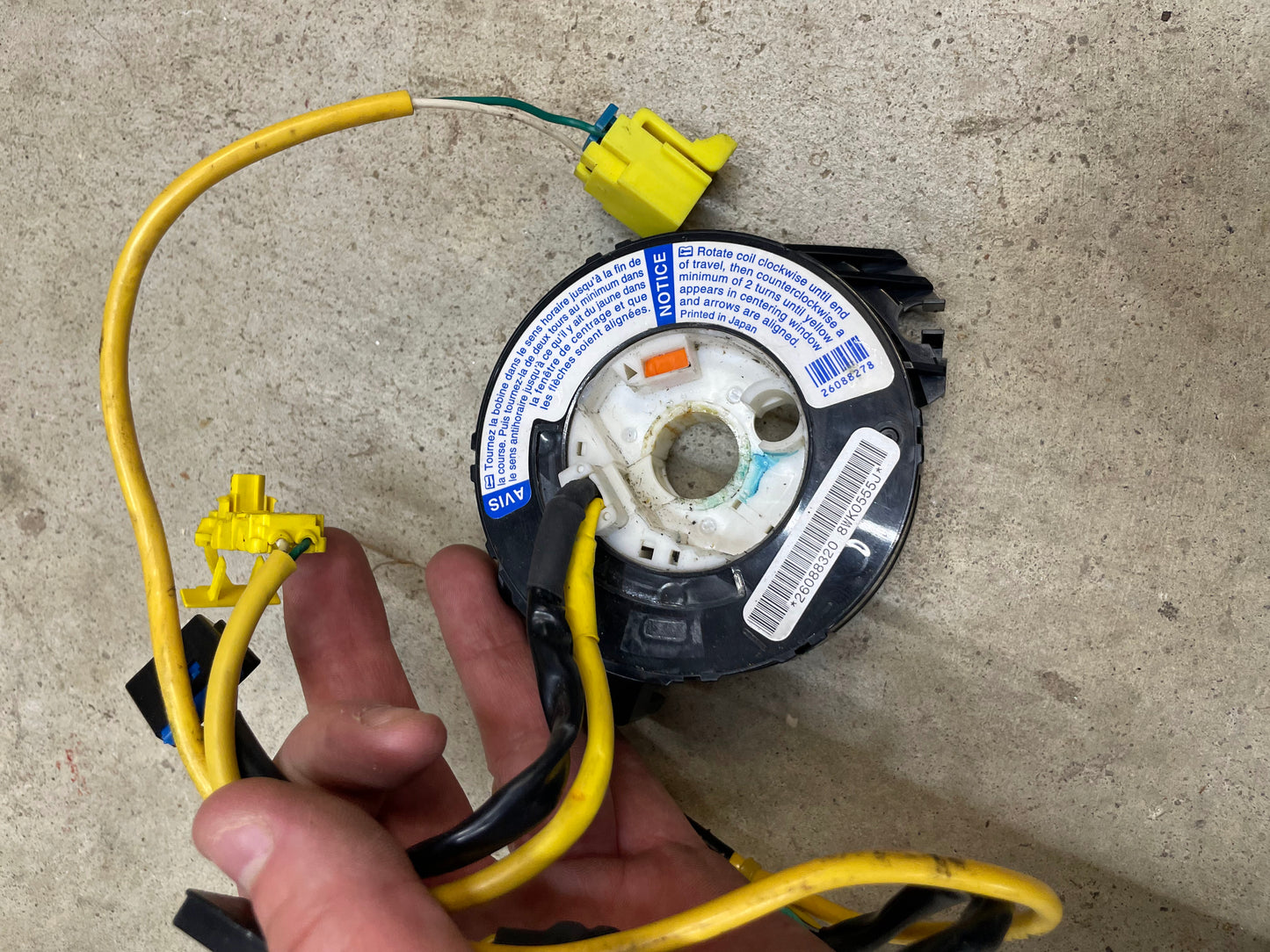 A hand holds a KIT Leather w/Wood Steering Wheel & Radio Controls from Escalade (1995–2005 GM Trucks) by General Motors—perfect for repairing or upgrading your steering wheel.