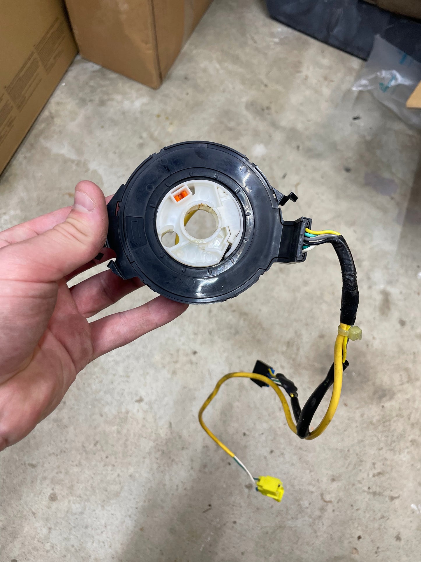 A hand displays a General Motors KIT Leather w/Wood Steering Wheel & Radio Controls from Escalade, designed for 1995-2005 GM trucks, with exposed wires—perfect for steering wheel replacements.