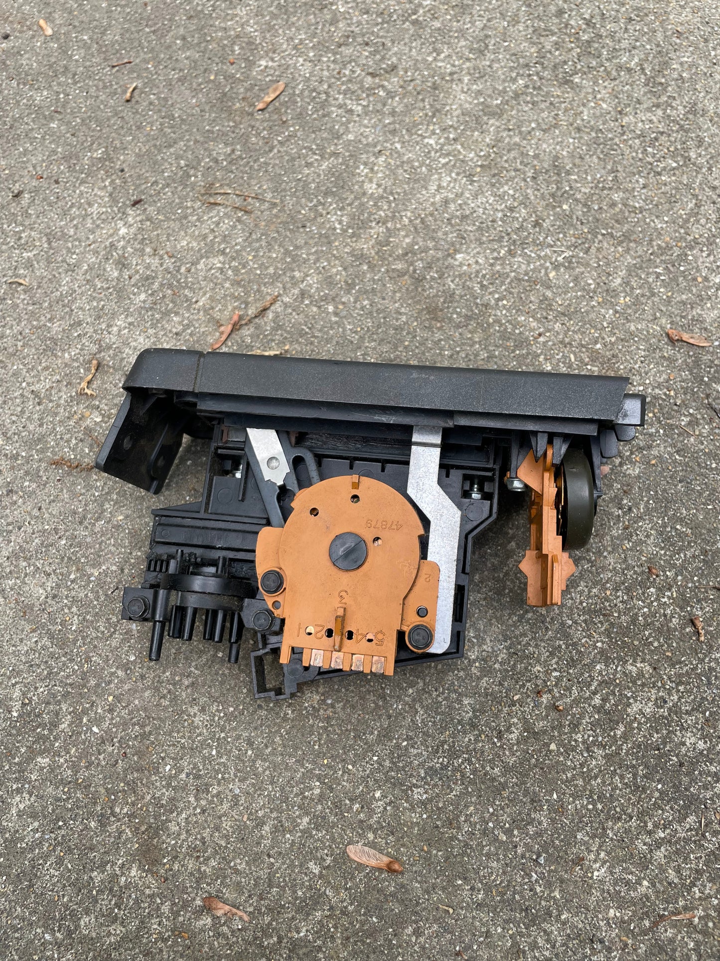 A close-up of a disassembled General Motors HVAC Heater Control Panel with A/C for 1986-1994 Chevrolet S10 and Blazer, showing exposed circuit boards and wiring on outdoor concrete.