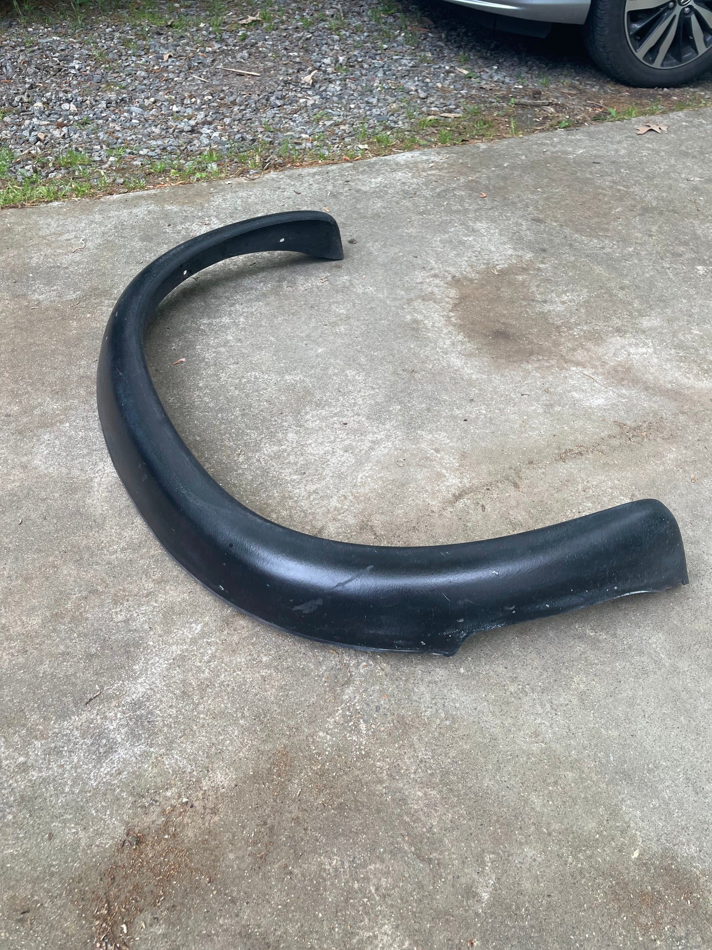 A General Motors OEM Set ZR2 Fender Flares Extension for 1994-2004 Chevy S10 or GMC Sonoma sits on a concrete driveway, with gravel and part of a Chevrolet S10 ZR2 tire visible in the background.