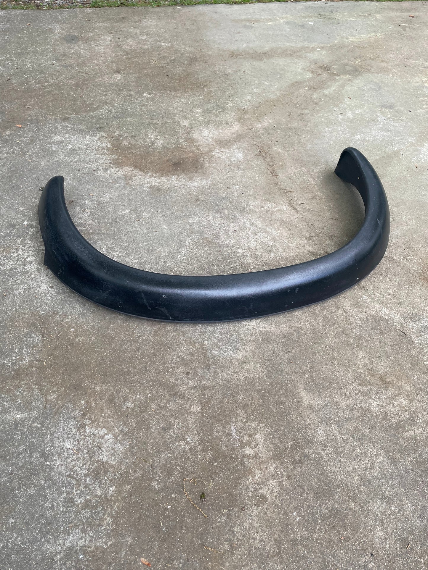 A General Motors OEM Set ZR2 Fender Flare Extension for 1994-2004 Chevy S10 or GMC Sonoma is lying on a concrete surface outdoors.