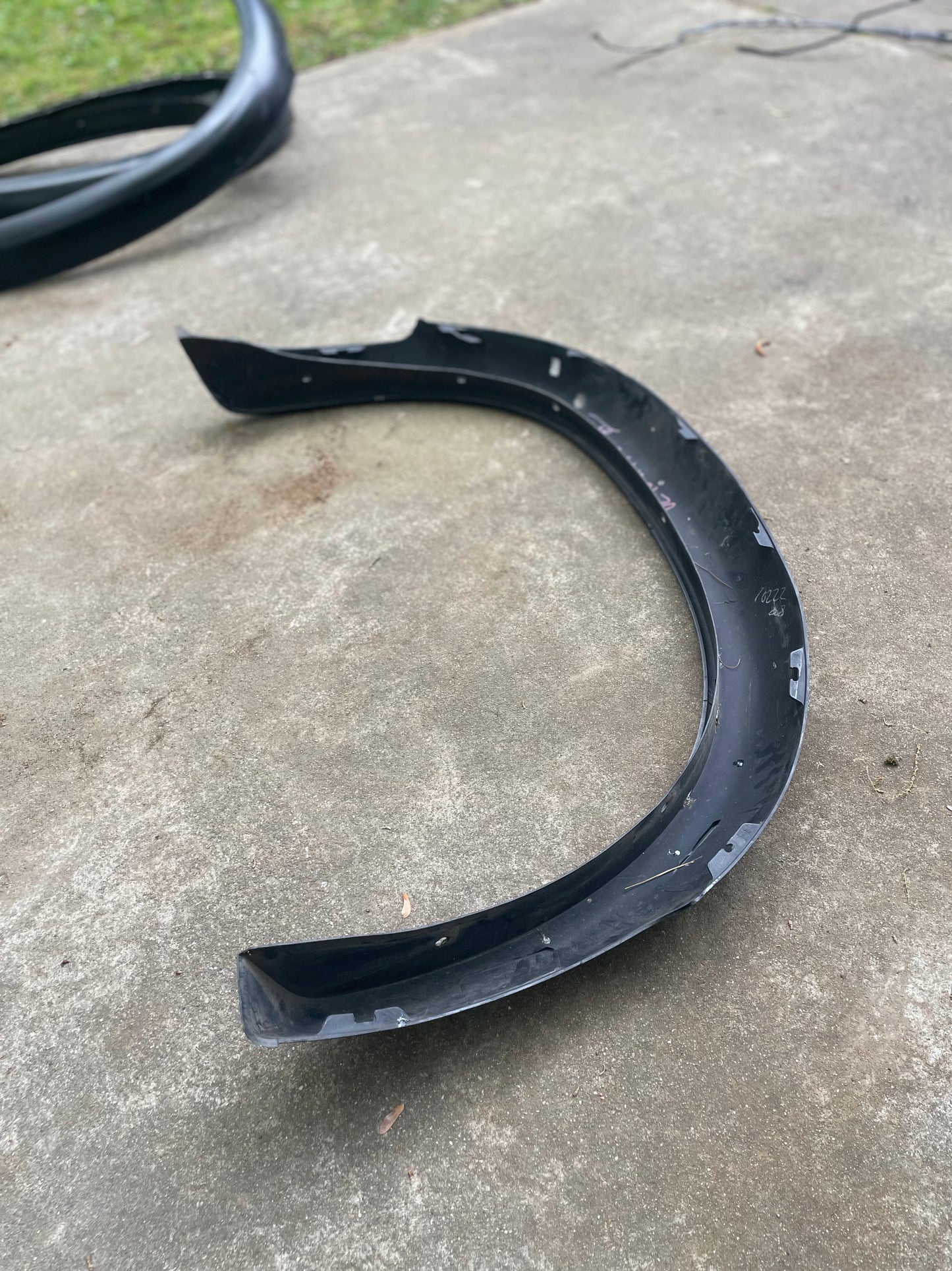 A General Motors OEM Set ZR2 Fender Flares Extension for 1994-2004 Chevy S10 or GMC Sonoma is seen outdoors on concrete, with grass in the background.