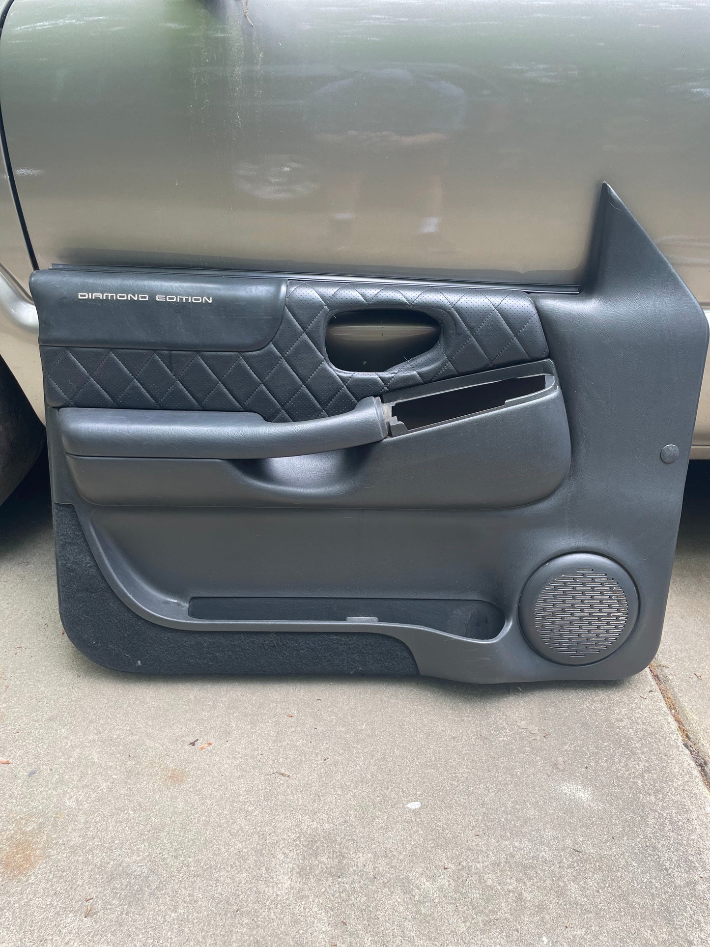 General Motors OEM pair of front power leather diamond door panels in dark gray for 1998-2005 Chevy S10, GMC Sonoma, and more, shown removed with visible speaker grille and handle—an upgrade over factory S10 interior panels.