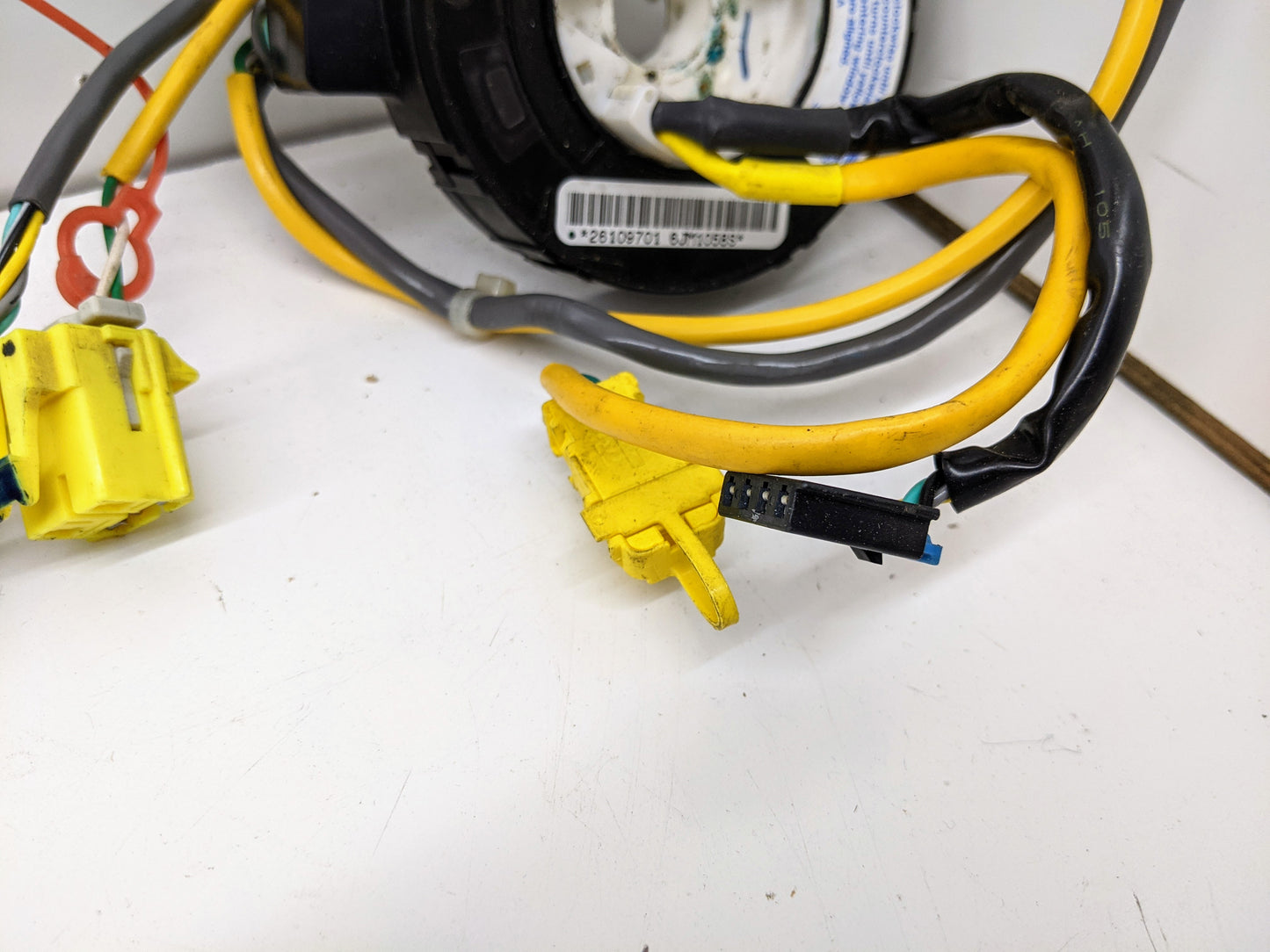 Close-up of yellow and black connector wires from the General Motors OEM Steering Wheel SRS Air Bag Clock Spring w/Radio Controls, tested for 2004-2005 Chevy S10 Blazer and more, shown on a white surface.