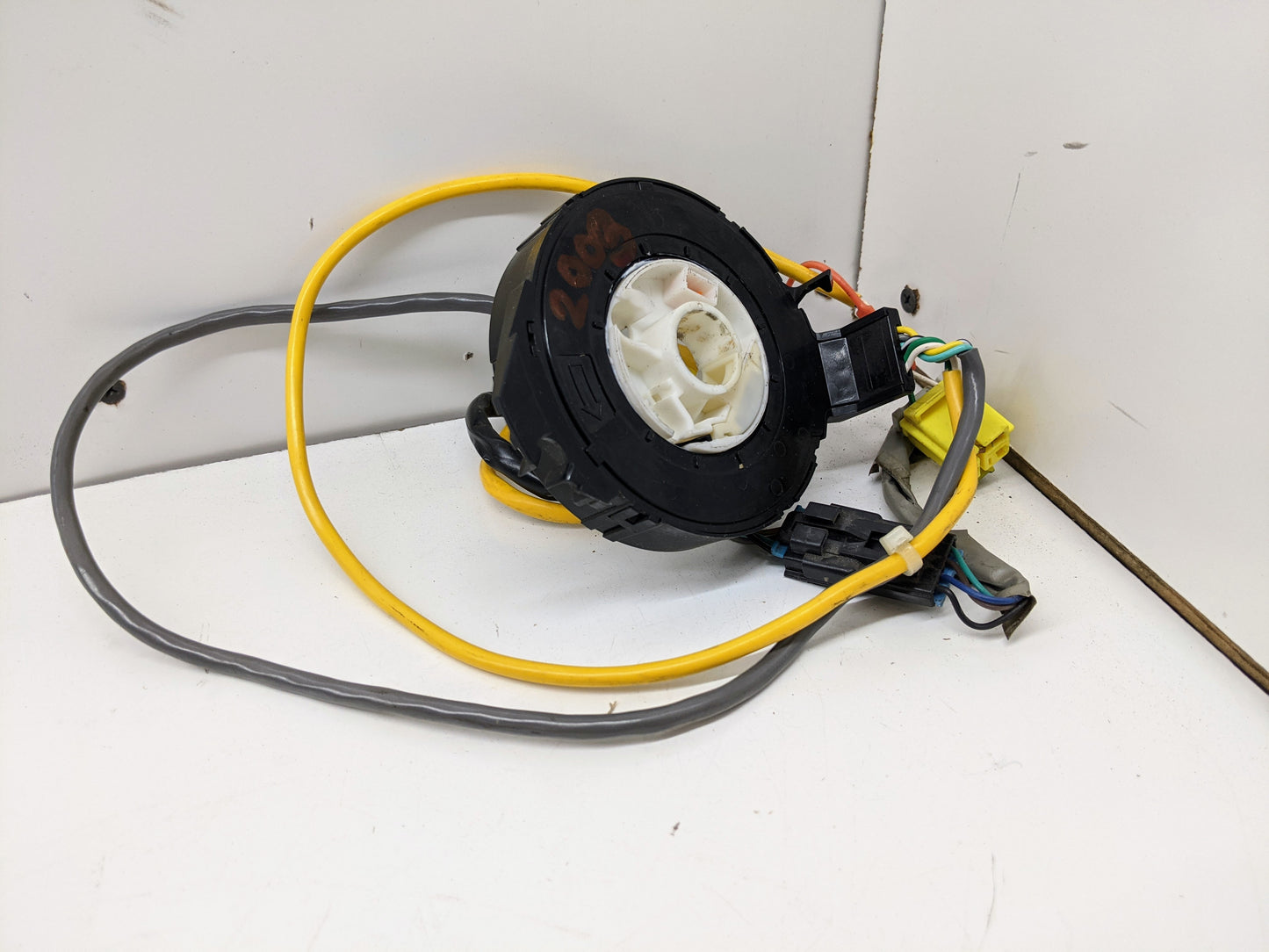 A General Motors OEM Steering Wheel SRS Air Bag Clock Spring, tested with radio controls, for 2004-2005 Chevy S10 Blazer and more—features black-and-white circular design with yellow and gray wires, connectors, and plugs.