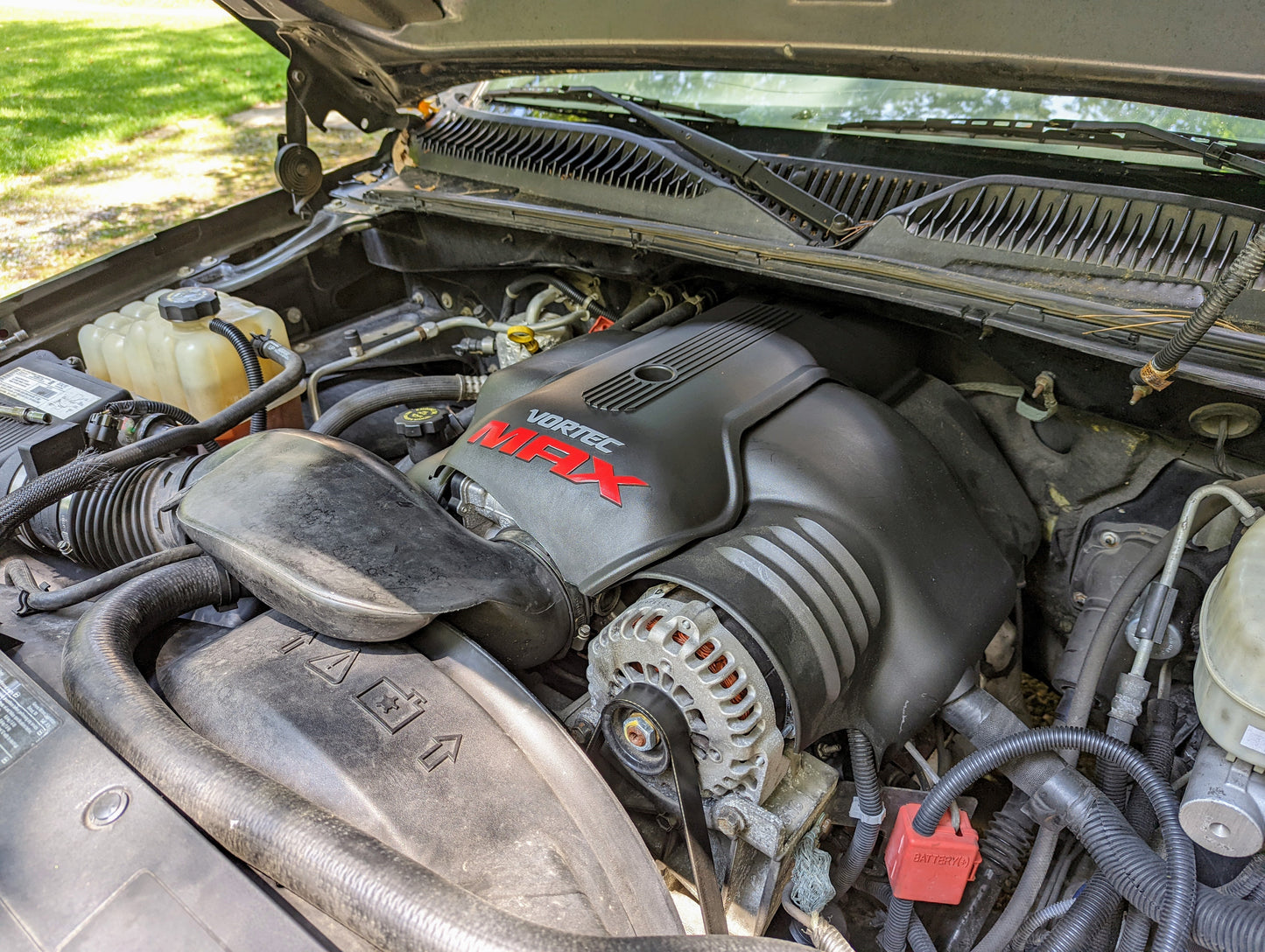 A close-up of a General Motors Vortec MAX V8 engine bay highlights OEM Engine Cover Grommets Bushings for GM Truck LS Swap Vortec MAX & 6000, with engine covers and components visible beneath the raised hood.