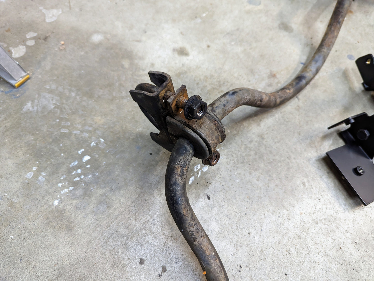 A KIT ZQ8/Xtreme Rear Sway Bar with NEW Brackets by The Ugly Truckling for 1982-2004 Chevrolet S10, GMC S15, and Sonoma is on a concrete floor, surrounded by scattered black metal suspension parts.