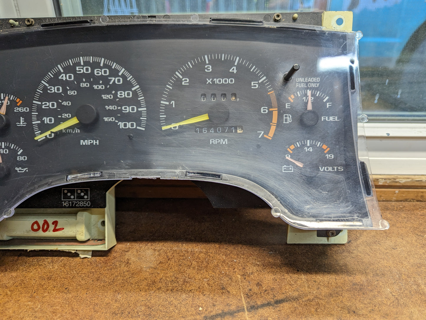 A General Motors OEM Instrument Cluster with Tachometer for 1995-1997 Chevy S10 or Blazer (with console shifter) is shown close-up, displaying analog speed, RPM, fuel, temperature, and voltage gauges; odometer reads 164071 miles.