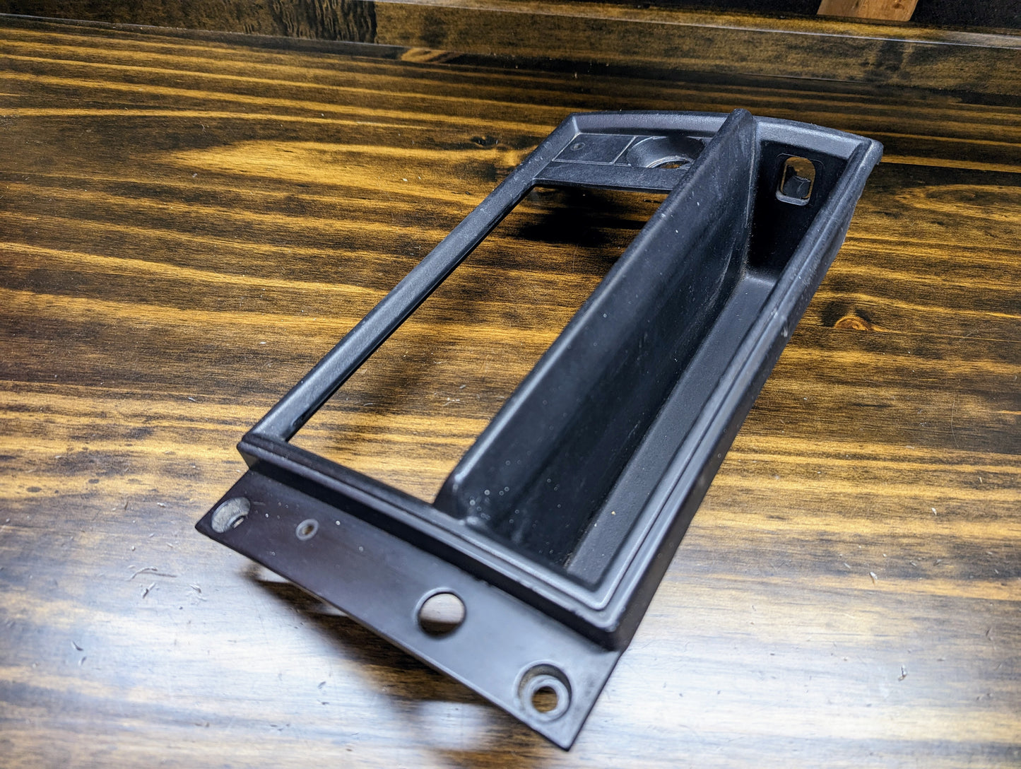 A General Motors OEM Radio Dash Bezel w/Vent Delete in Black, designed for 1986-1993 Chevy S10, Blazer, GMC S15, and more, shown with a rectangular opening and slanted pocket—ideal for adding storage to your vehicle’s dash.