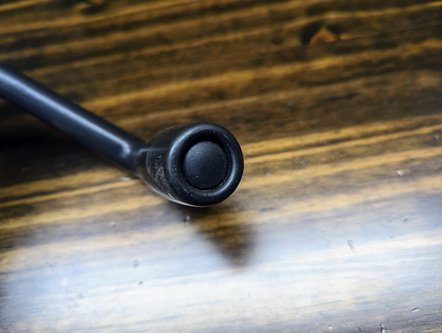 A close-up shows a black knob on a metallic rod, part of the General Motors OEM Column Shift Lever with Tow/Haul for 1999-2006 GM Full Size Trucks, placed on a wooden surface with visible grain.