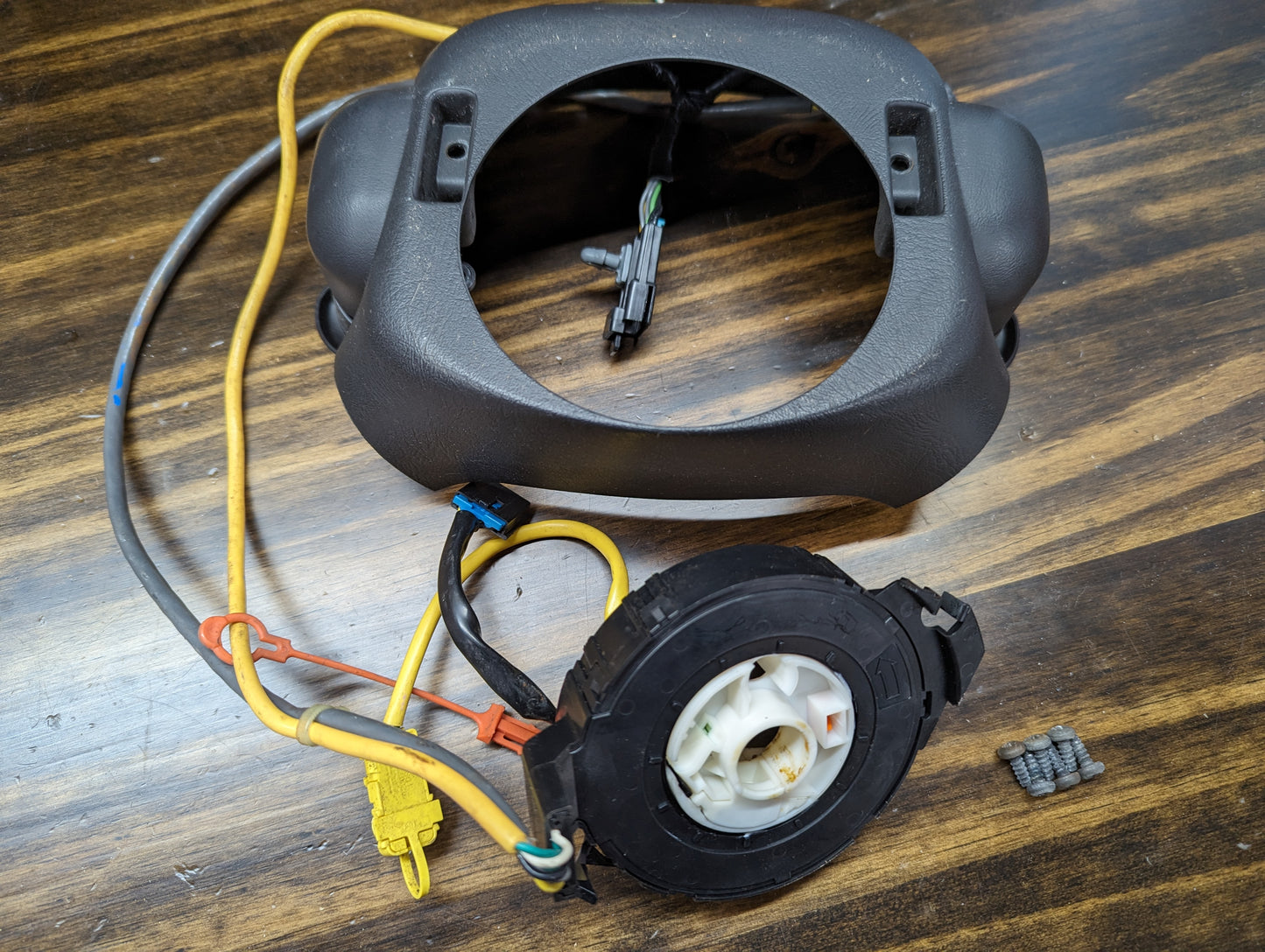 A General Motors KIT Steering Wheel Black Button Radio Controls & Clock Spring for 2000-2003 Chevy S10, Blazer, and more is shown disassembled with wiring harness and cover—ideal for a steering wheel controls upgrade or replacement.