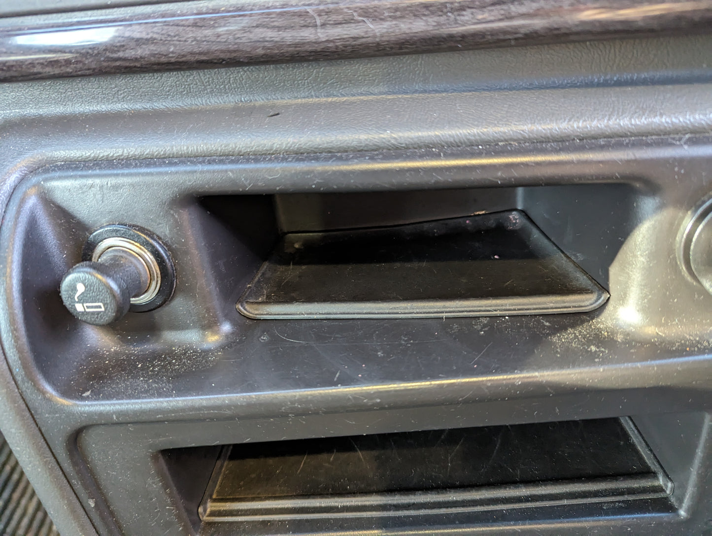 Close-up of a GM OEM Center Console Front Trim Upper Bin Rubber Mat Liner by General Motors for 2003-2006 Chevy Silverado/GMC Sierra, showing the dashboard area with dust and scratches.