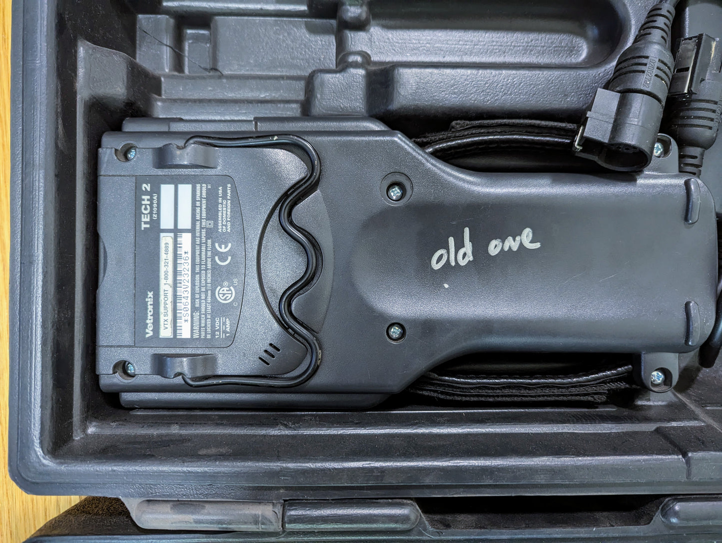A TESTED Vetronix Tech 2 Automotive Diagnostic Tool & Accessories for 1991-2013 GM Vehicles, labeled old one in white marker, is shown in a carrying case with OBD2 cables beside it.