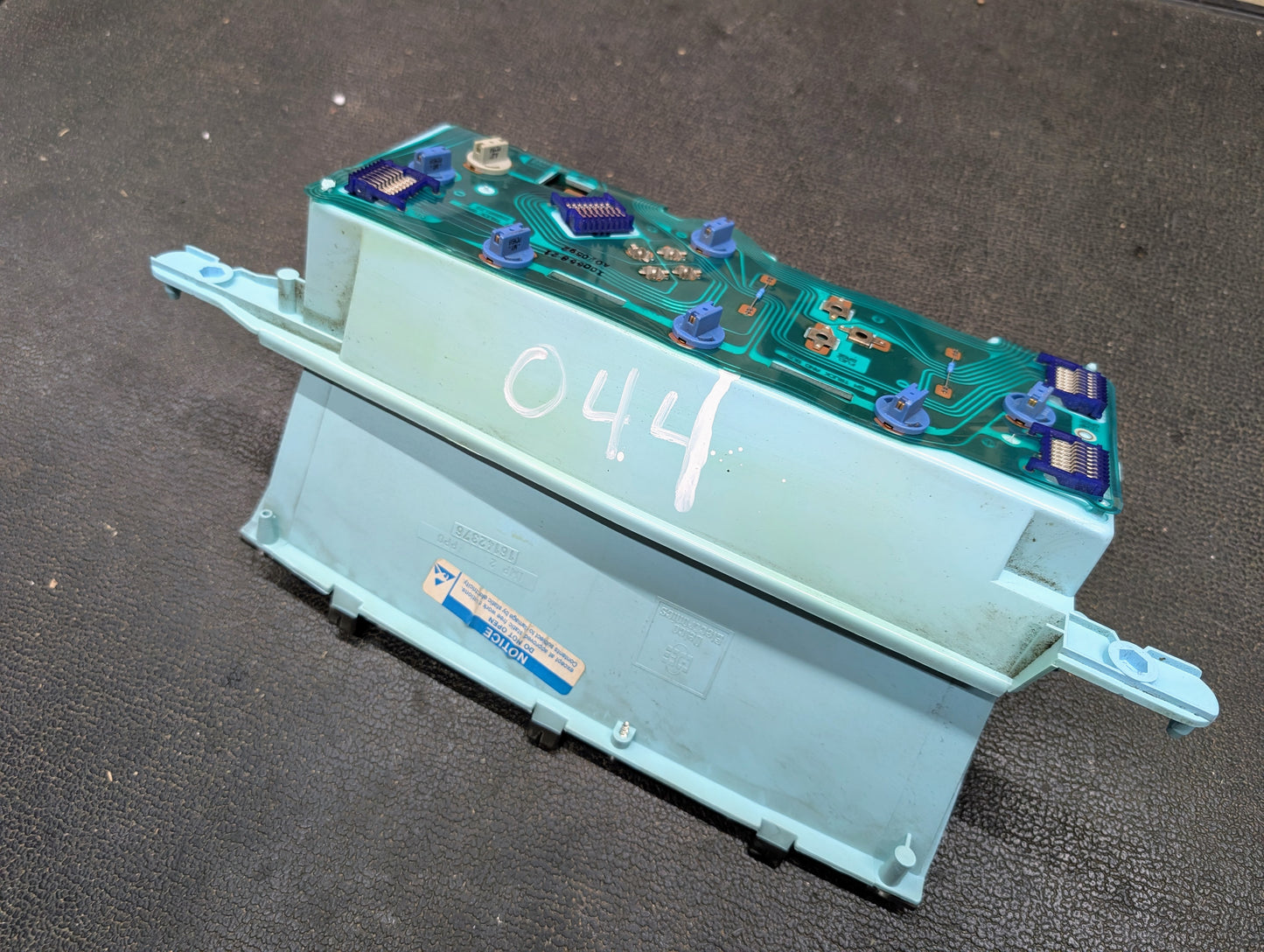 This General Motors OEM Instrument Cluster fits 1986-1994 Chevy S10, Blazer, and more. It features a green circuit board marked 044 and light blue housing, typical for analog clusters from this era.