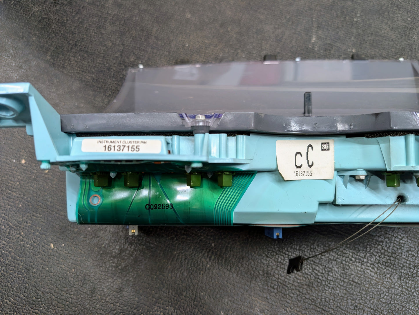 Close-up of a General Motors OEM Instrument Cluster with PRNDL and 110 mph Speedo for 1986-1994 Chevy S10 Blazer, showing circuit board details and INSTRUMENT CLUSTER sticker with number 16137155 on a textured black surface.