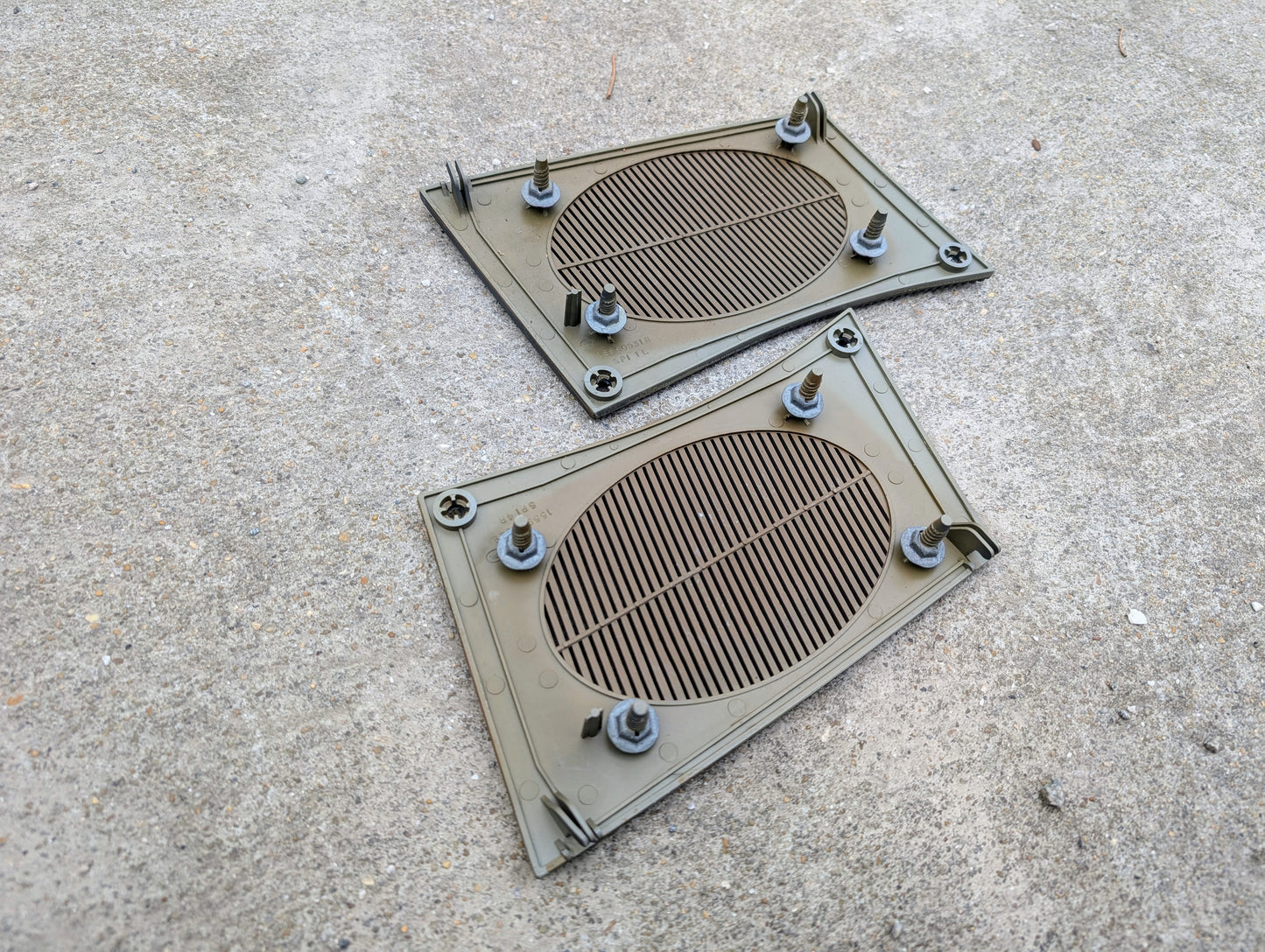 Two plastic grates with nuts on a concrete surface