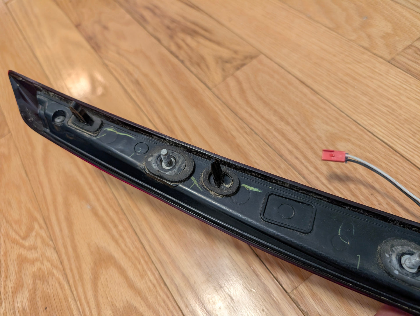 A close-up of a General Motors OEM 2008-2013 Cadillac CTS Rear Stop Third Brake Light CHMSL with mounting bolts and wire connector—an essential tested trunk lamp for your Cadillac CTS.