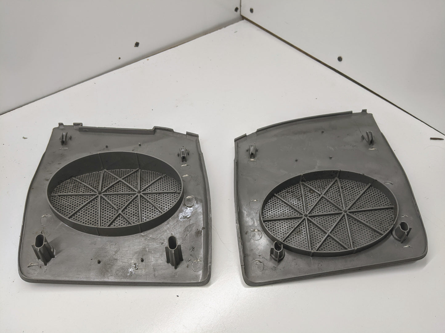 A pair of light gray OEM LH/RH dash speaker grille covers by General Motors for 1995-1997 Chevrolet S10, Blazer, and more are shown side by side; each features mounting posts and tabs along the edges.
