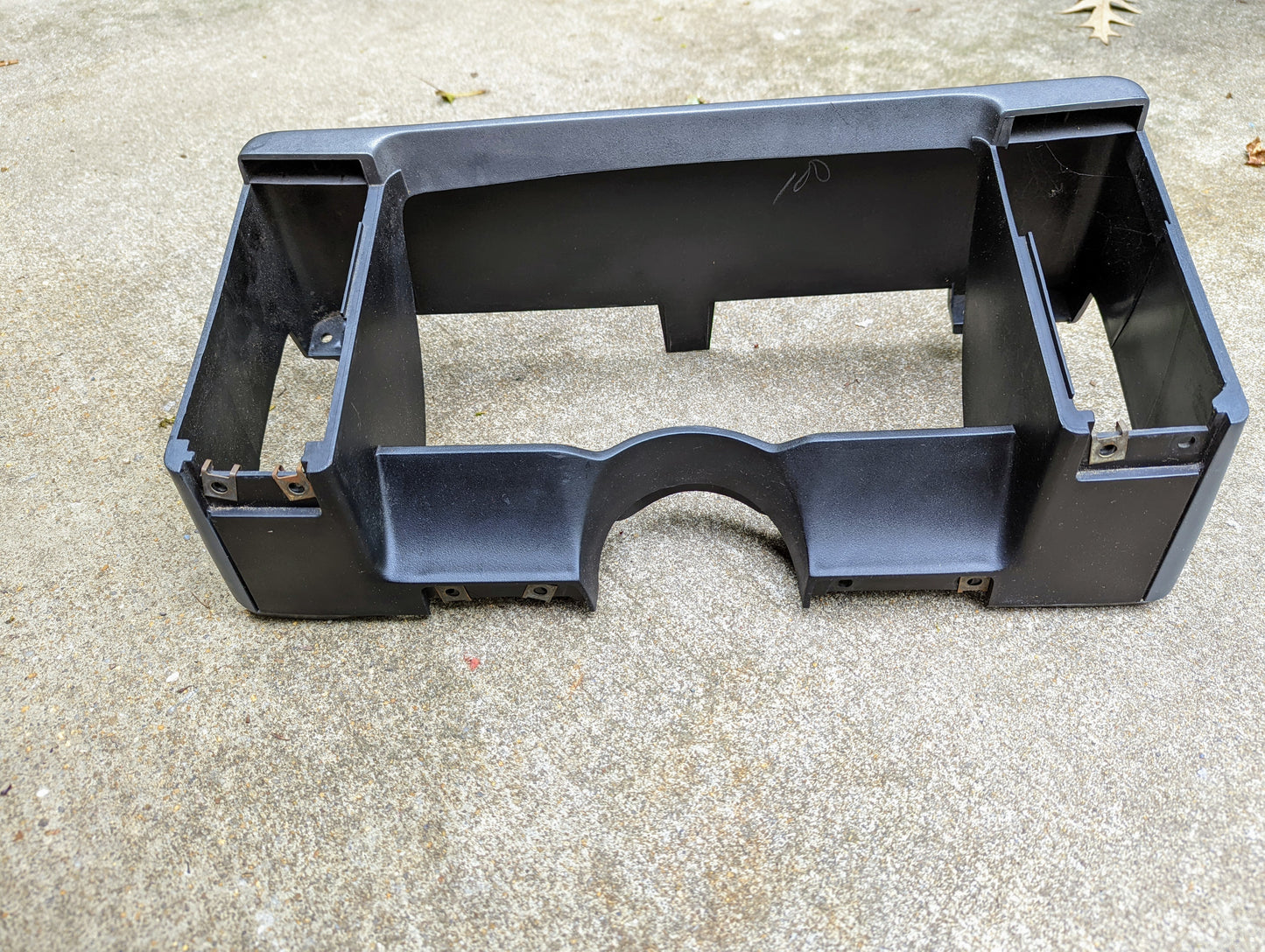 The image shows a gray OEM Instrument Cluster Dash Bezel by General Motors for 1986-1993 Chevy S10, Blazer, GMC S15, and more. It has multiple compartments and cutouts for gauges and controls, with mounting brackets attached.