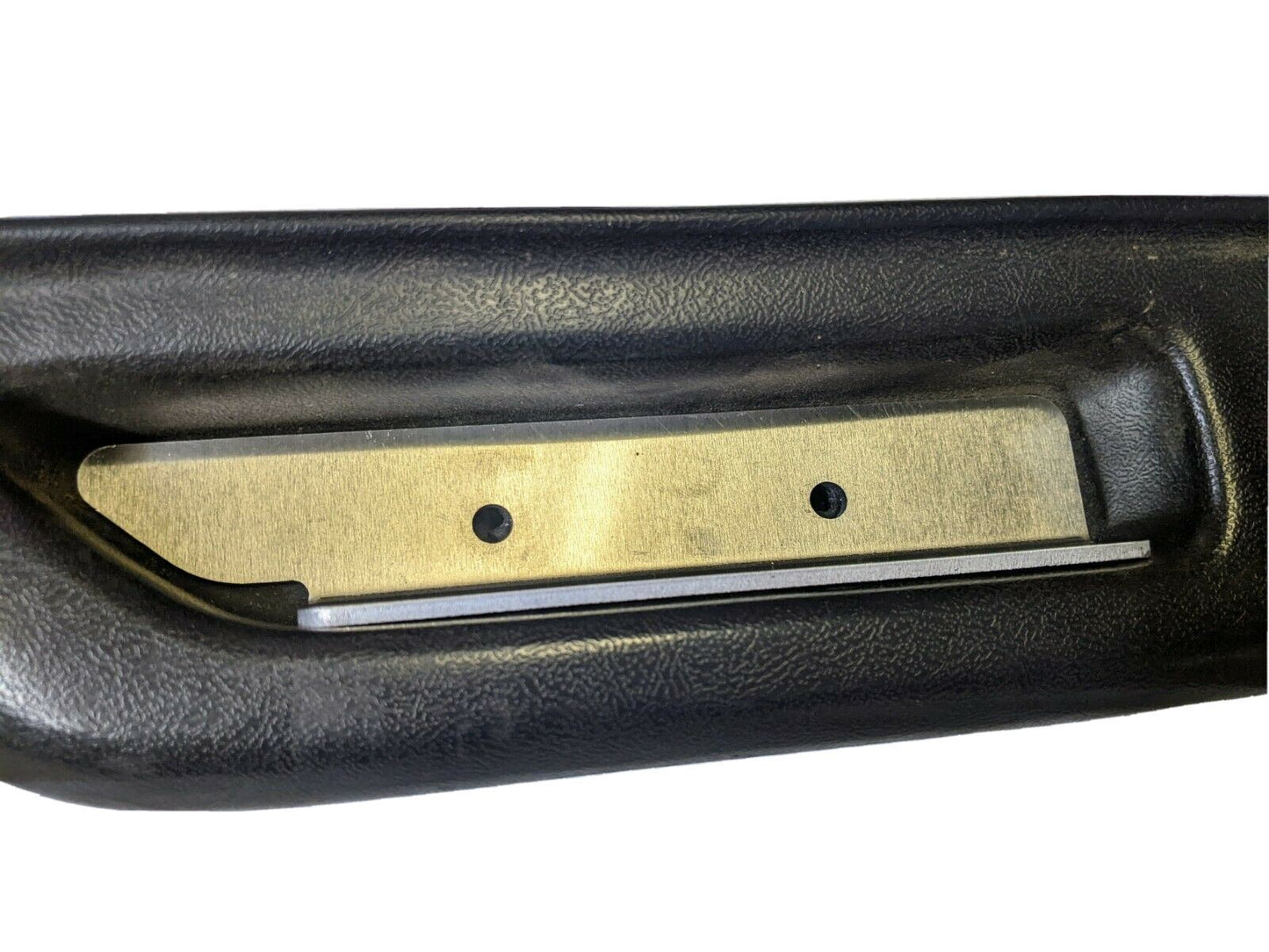 Close-up of a black plastic handle from The Ugly Truckling KIT Door Panel Armrest Repair w/Hardware for 1986–1993 Chevy S10, Blazer, GMC S15, and Jimmy. It features a central metal plate with two holes and a textured surface for durability.