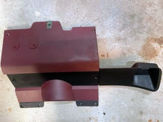 A red OEM Lower Dash Trim Knee Bolster by General Motors for 1986-1993 Chevy S10 Blazer, GMC S15, and more rests on a concrete surface.