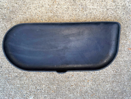 A black, rounded OEM Center Console Cup Holder Accessory Bin Driver Side Rubber Mat Liner by General Motors rests on gray concrete—solid and smooth, made for 2003-2006 Chevy Silverado, GMC Sierra, and more full size trucks.