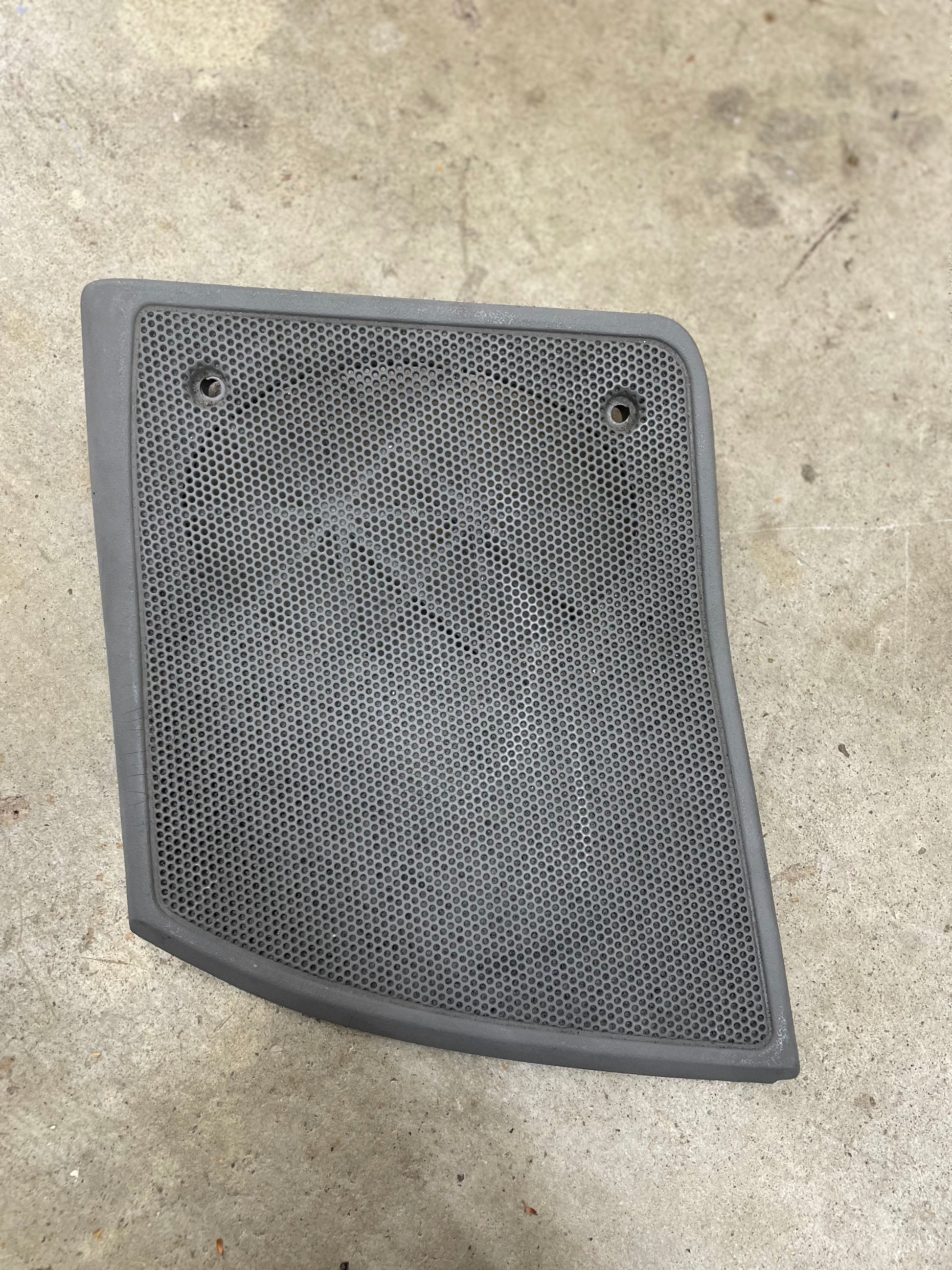 A light gray OEM passenger RH dash speaker grille cover by General Motors, with a broken tab, designed for 1995-1997 Chevrolet S10, Blazer, and more models.