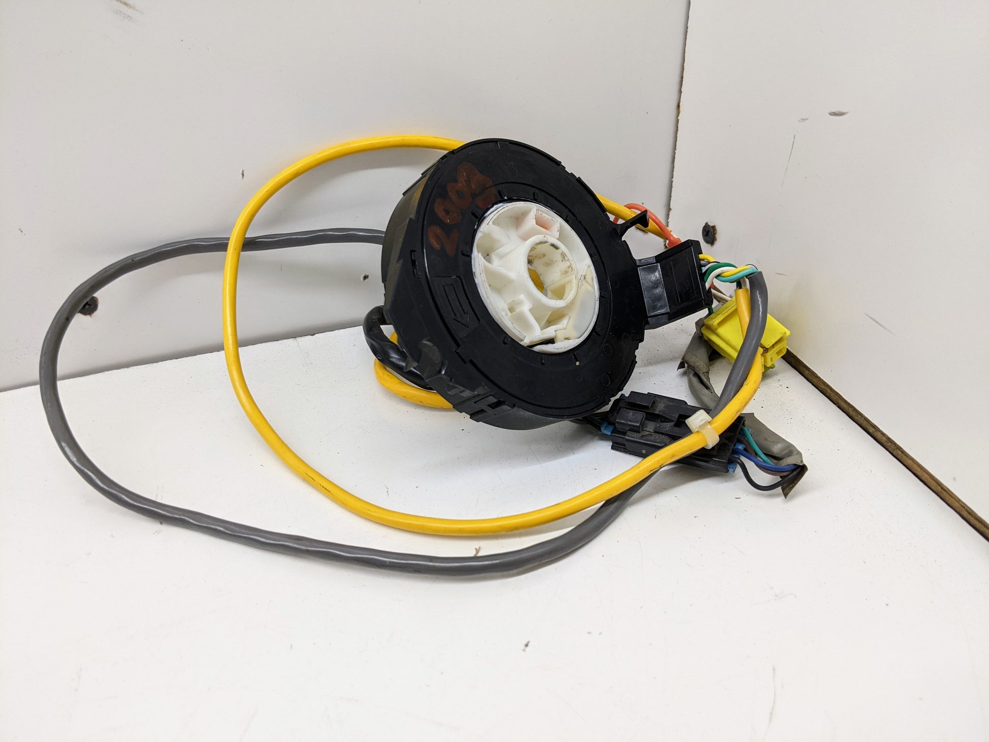 A General Motors OEM Steering Wheel SRS Air Bag Clock Spring, tested with radio controls, for 2004-2005 Chevy S10 Blazer and more—features black-and-white circular design with yellow and gray wires, connectors, and plugs.