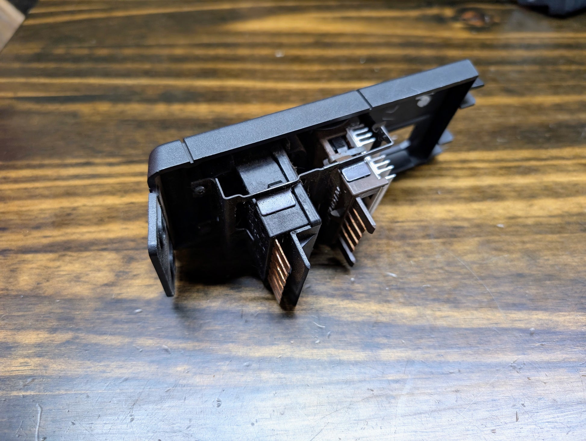 A close-up of two network RJ45 ports in a black plastic panel on wood, their metal connectors visible—crafted with precision akin to a General Motors OEM Headlight Switch for 1986–1994 Chevy S10, Blazer, GMC S15 & Jimmy.