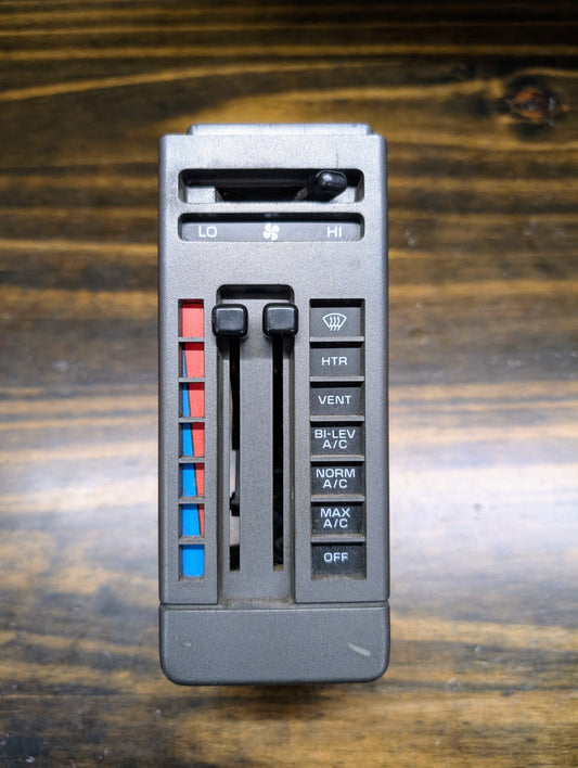Close-up of a General Motors HVAC Heater Control Panel with A/C for 1986-1994 Chevrolet S10, Blazer and more, featuring sliding levers for temperature and fan speed, a blue-to-red scale, and mode buttons.
