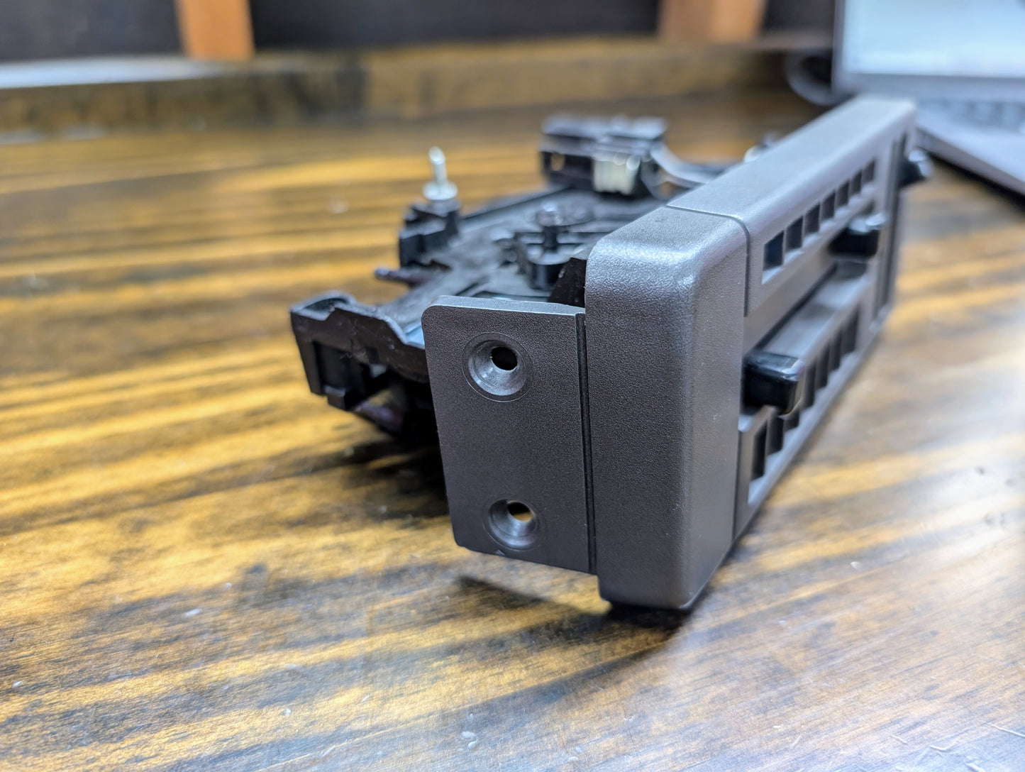 A black plastic General Motors HVAC Heater Control Panel with A/C sits on a wood surface, designed for 1986–1994 Chevrolet S10, Blazer, and more.