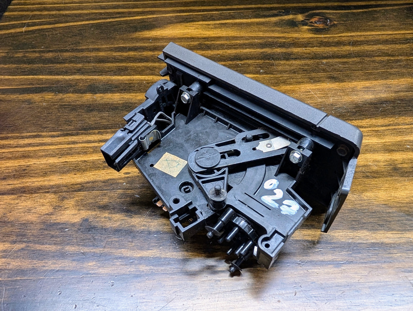 A black, rectangular General Motors HVAC Heater Control Panel with A/C for 1986-1994 Chevrolet S10, Blazer, and more sits on a wood-grain surface. White handwritten 022 is marked on one side.