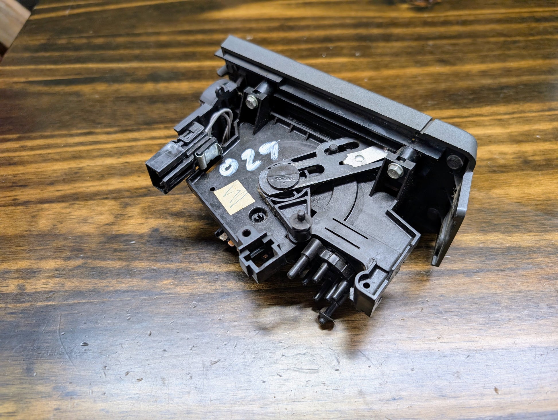 A black General Motors HVAC Heater Control Panel with A/C, marked 620 in white, is shown on a wooden surface—fits 1986-1994 Chevrolet S10, Blazer, and more.