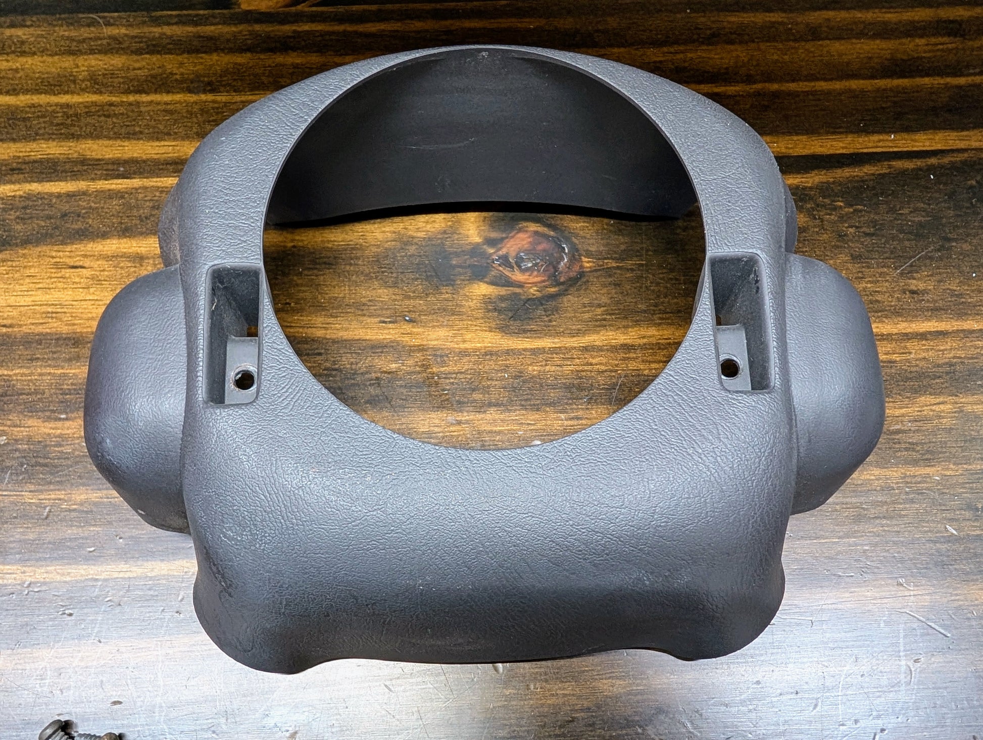 A General Motors KIT Steering Wheel Radio Controls & Clock Spring for 1999 Chevy S10, Blazer, and more rests on a wooden surface with visible grain patterns.