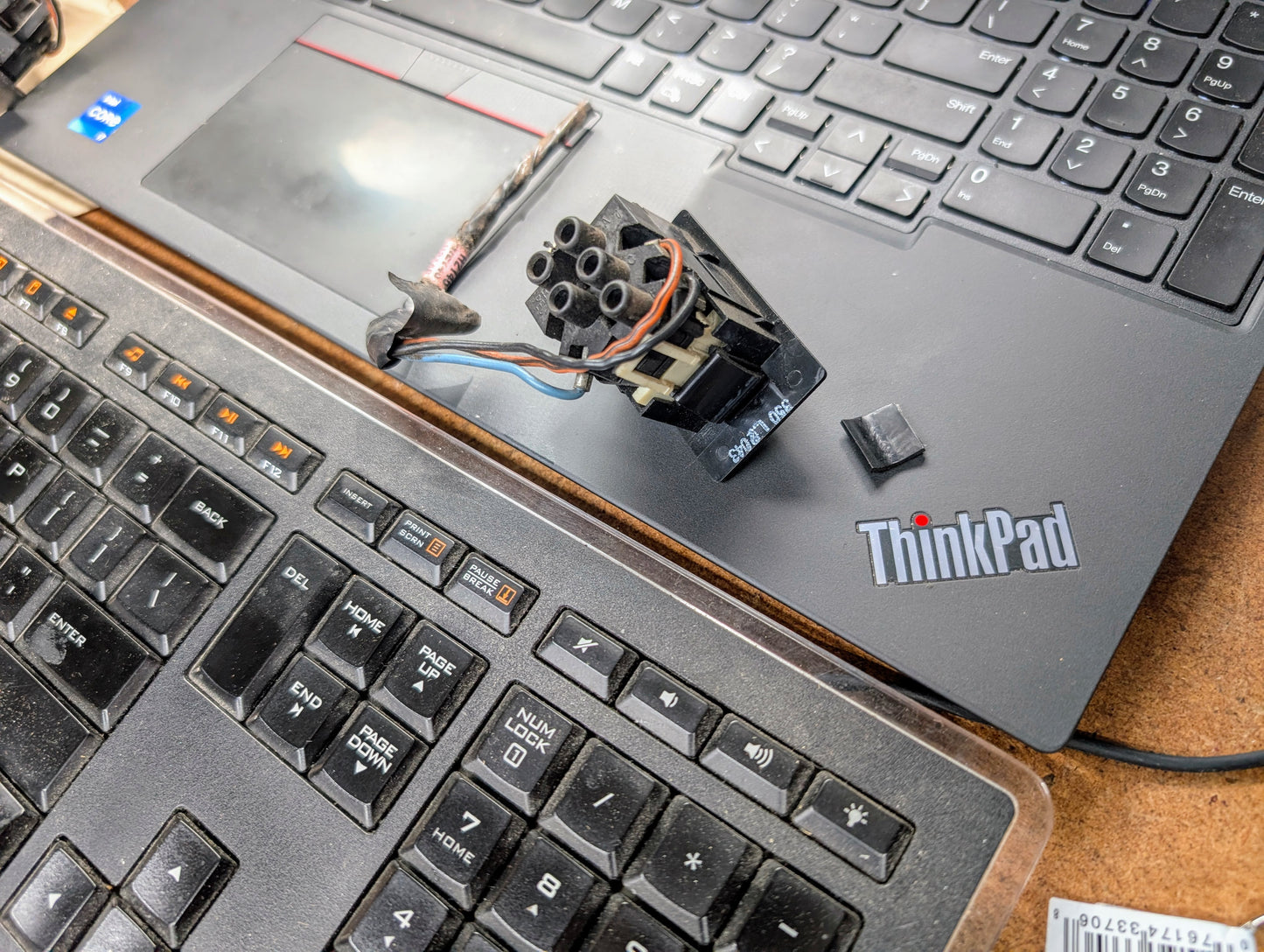 A close-up shows two overlapping keyboards, one older and one Lenovo ThinkPad, with a General Motors OEM Driver LH Power Door Lock Switch for 1991-1994 Chevy S10 Blazer and small electronic parts on top.