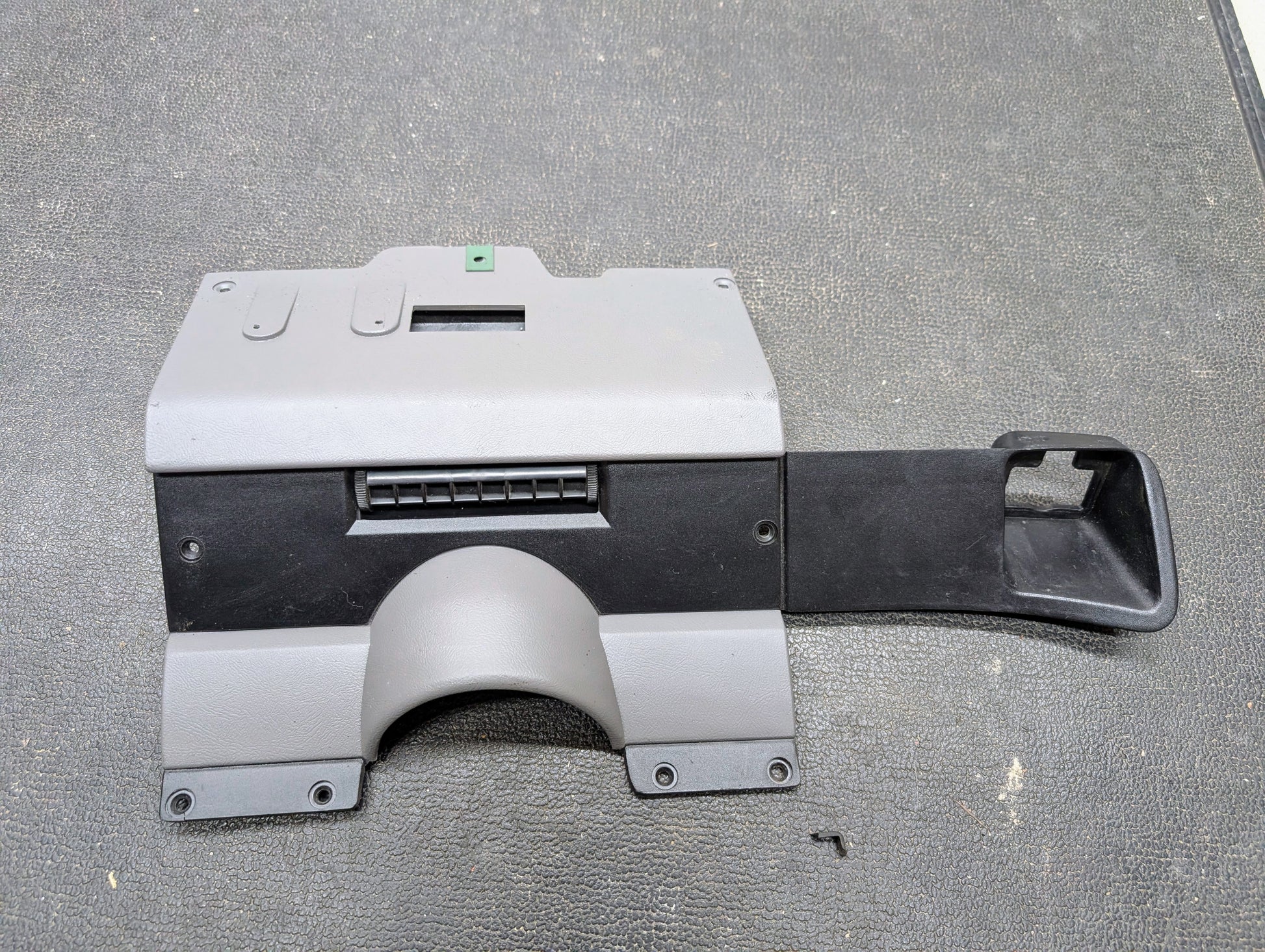 The General Motors OEM Lower Dash Trim Knee Bolster in Lt Gray fits 1986-1993 Chevy S10 Blazer, GMC S15, and more; features vents and mounting holes, shown on a textured dark surface.