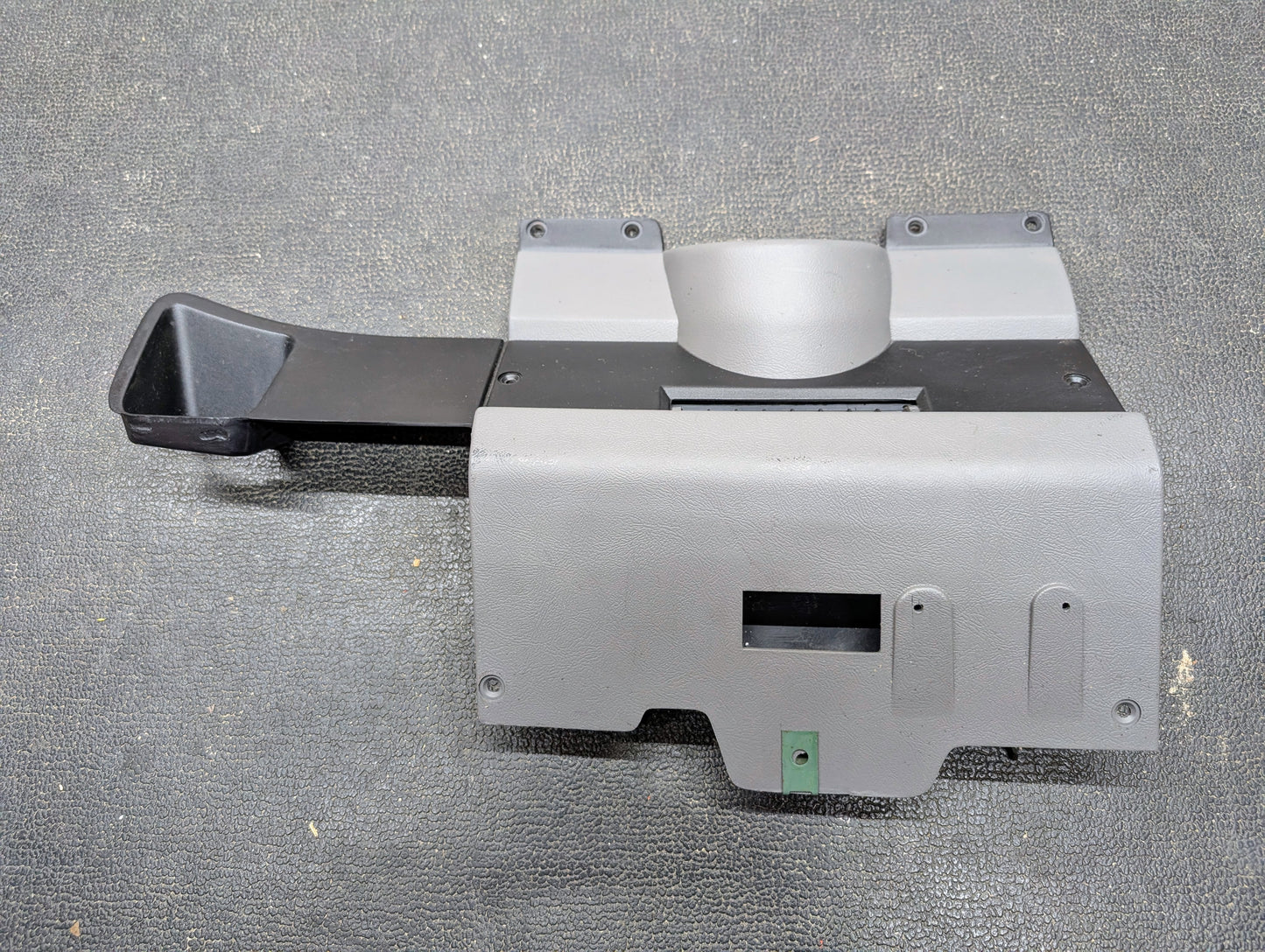 An OEM Lt Gray General Motors Lower Dash Trim Knee Bolster for 1986–1993 Chevy S10 Blazer/GMC S15, featuring a left black vent, multiple openings, and mounting holes, shown on a textured dark surface.